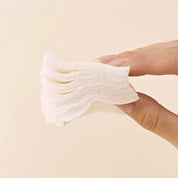 Heveblue cotton pad soaked in toner held flat against skin as spot mask